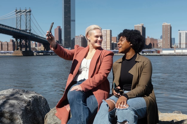 Mujeres de tiro medio tomando selfie al aire libre