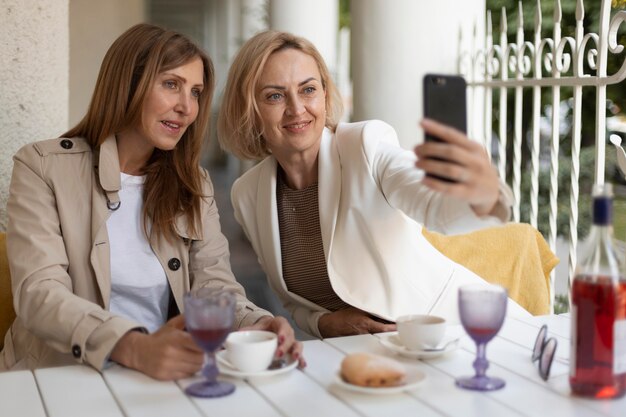 Mujeres de tiro medio tomando selfie