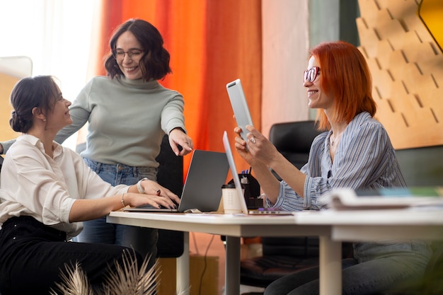 Mujeres de tiro medio trabajando juntas en la oficina