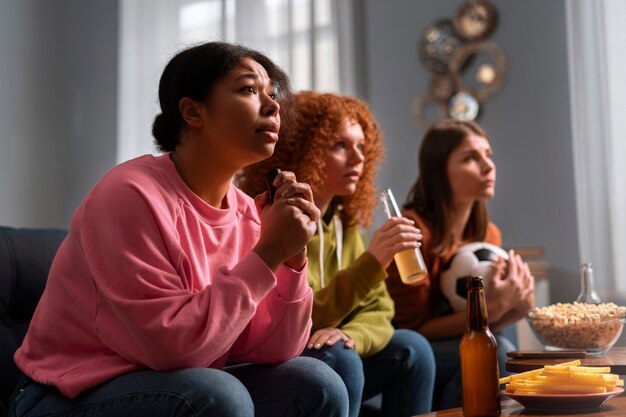 Mujeres de tiro medio viendo deportes