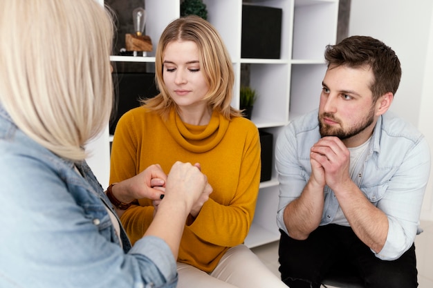 Mujeres tomados de la mano en la sesión de terapia