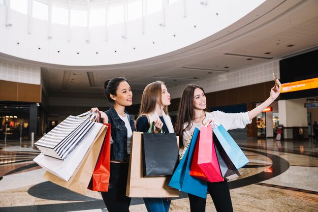 Mujeres tomando selfie con bolsas