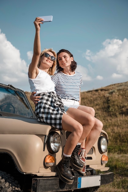 Mujeres tomando selfie mientras viaja en coche