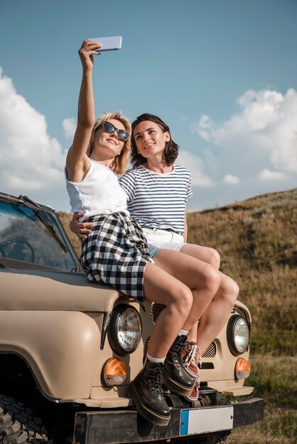 Mujeres tomando selfie mientras viaja en coche