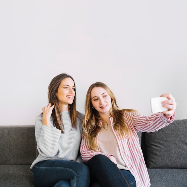 Mujeres tomando selfie en sofá