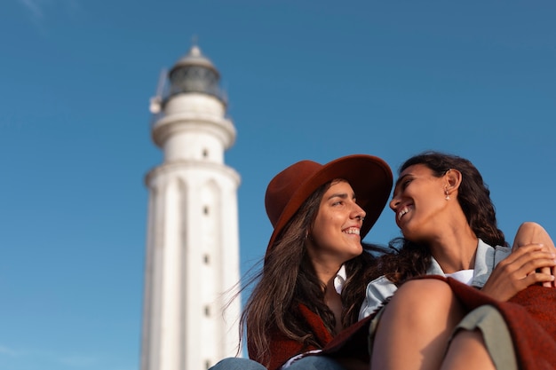 Mujeres de tomas medias posando con un faro