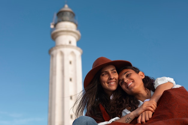 Foto gratuita mujeres de tomas medias posando con un faro