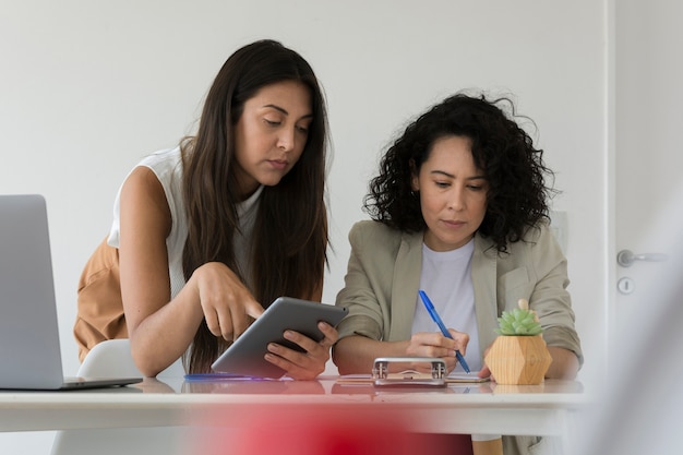 Mujeres trabajando juntas para resolver un problema del proyecto