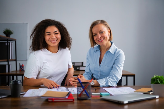 Foto gratuita mujeres trabajando juntas en la vista frontal de la oficina