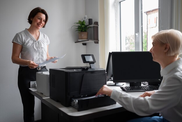 Mujeres en el trabajo en la oficina usando impresora