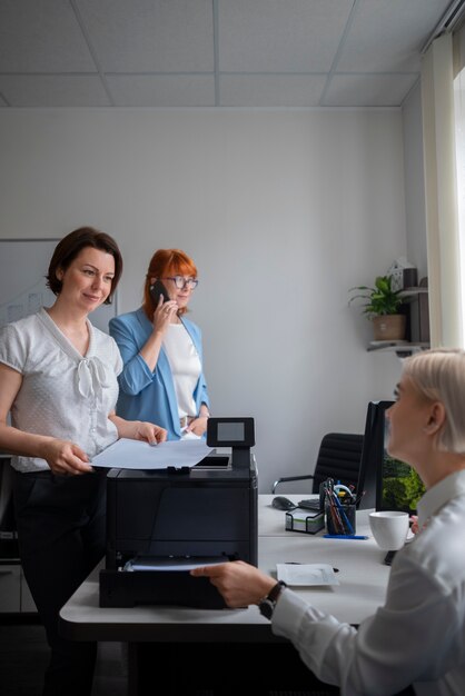 Mujeres en el trabajo en la oficina usando impresora