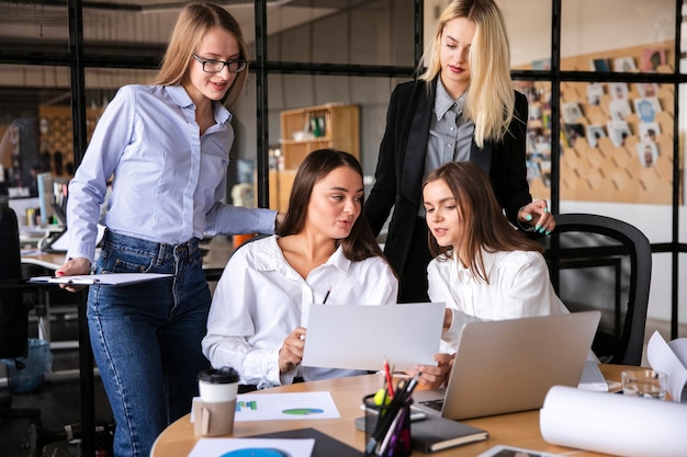 Mujeres en el trabajo utilizando dispositivos electrónicos.