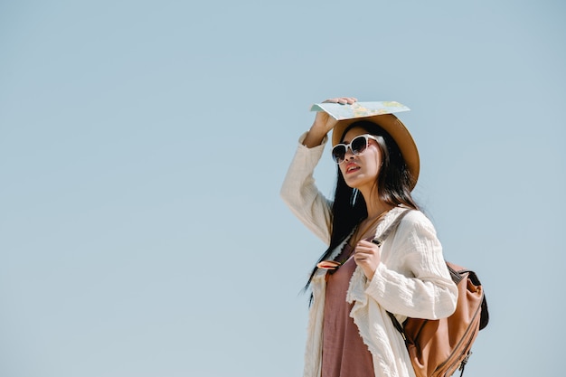 Mujeres turistas abren sus brazos y sostienen sus alas.