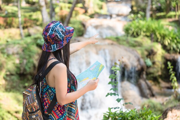 Mujeres turistas en mano tienen un feliz mapa de viaje.