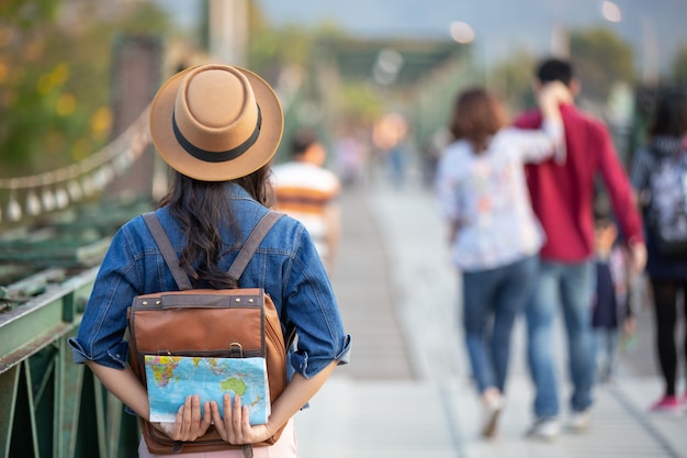 Mujeres turistas en mano tienen un feliz mapa de viaje.