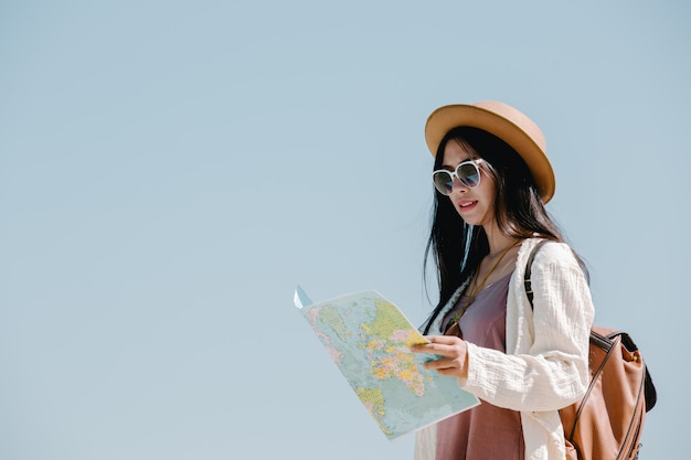 Mujeres turistas en mano tienen un feliz mapa de viaje.