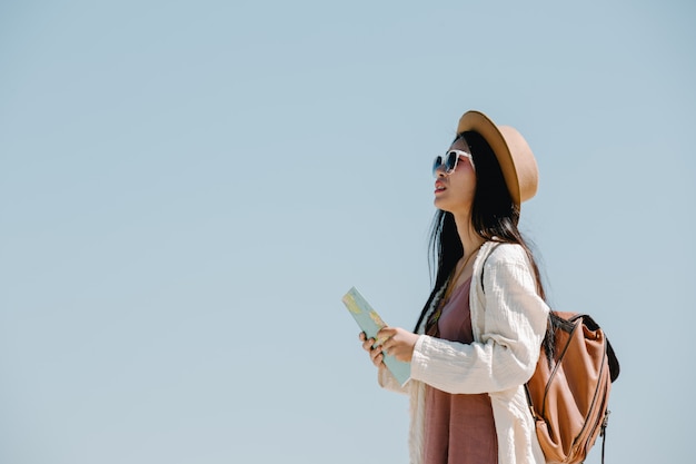 Mujeres turistas en mano tienen un feliz mapa de viaje.