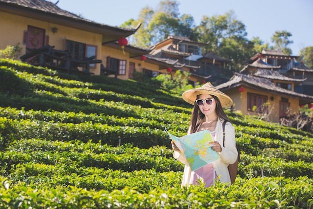 Mujeres turistas en mano tienen un feliz mapa de viaje.