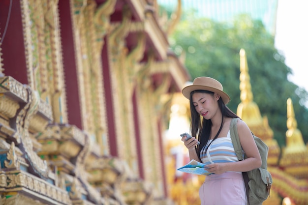 Mujeres turistas toman fotos con teléfonos móviles.