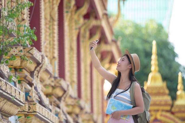 Mujeres turistas toman fotos con teléfonos móviles.