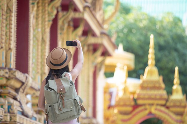 Mujeres turistas toman fotos con teléfonos móviles.