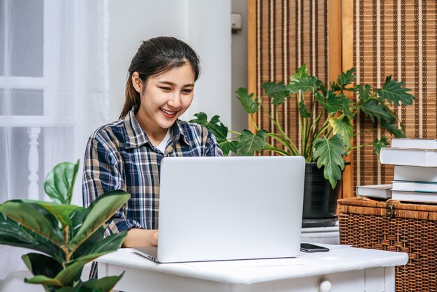 Las mujeres usan las computadoras portátiles en la oficina con placer.