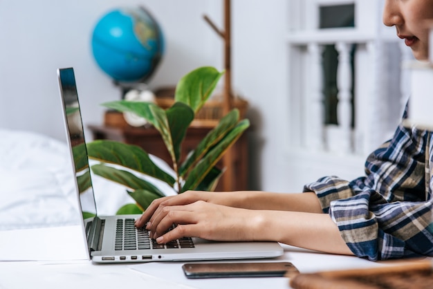 Las mujeres usan las computadoras portátiles en la oficina con placer.