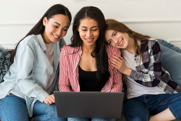 Foto gratuita mujeres usando laptop y sentados en el sofá