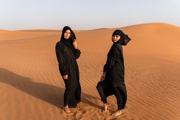 Mujeres vestidas con hijab en el desierto