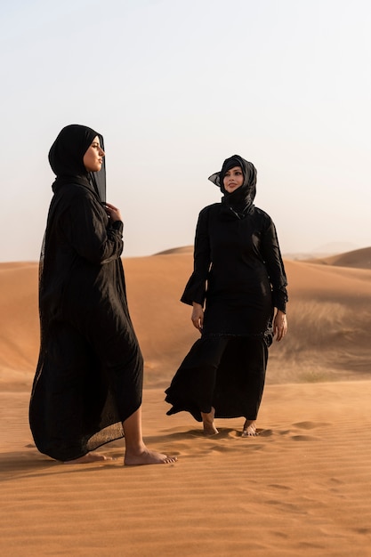 Mujeres vestidas con hijab en el desierto