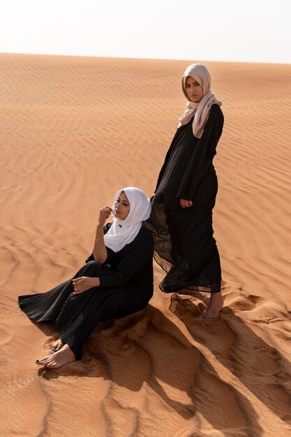 Mujeres vestidas con hijab en el desierto