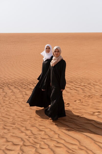 Mujeres vestidas con hijab en el desierto