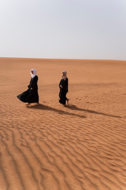 Mujeres vestidas con hijab en el desierto
