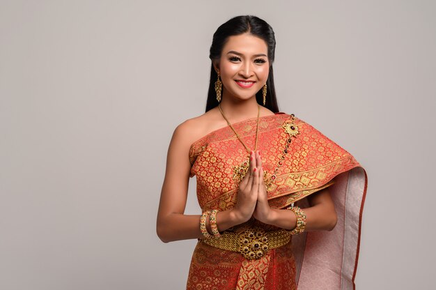 Mujeres vestidas con ropa tailandesa que rinden respeto, símbolo sawasdee