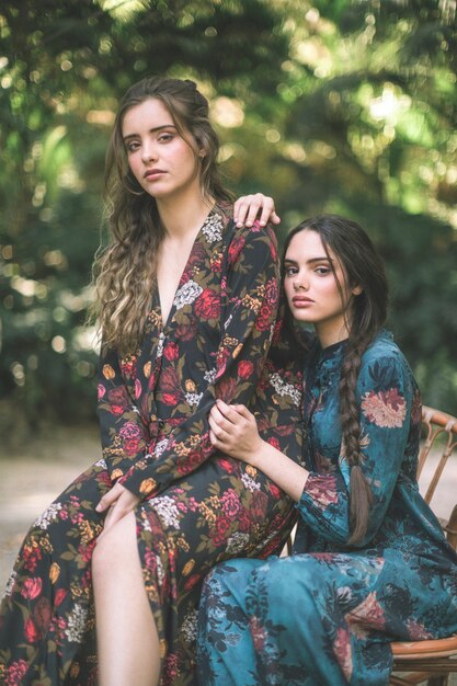 Mujeres en vestidos florales rodeadas de naturaleza