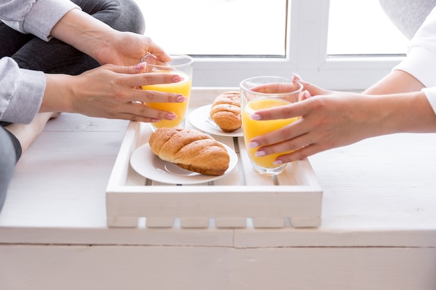 Mujeres de vista cercana que tienen jugo de naranja