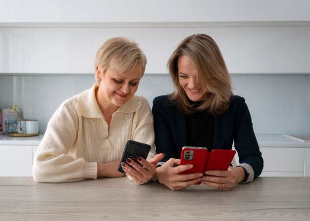 Mujeres de vista frontal leyendo mensajes de teléfono celular