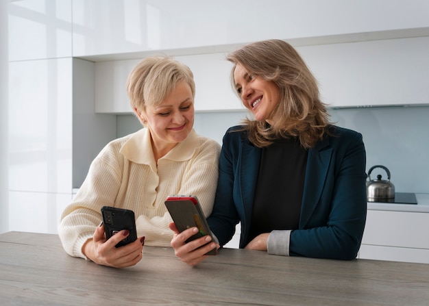 Foto gratuita mujeres de vista frontal leyendo mensajes de teléfono celular