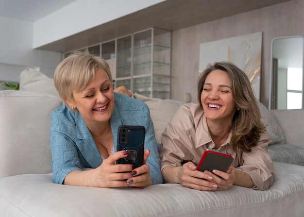 Mujeres de vista frontal leyendo mensajes de teléfono celular