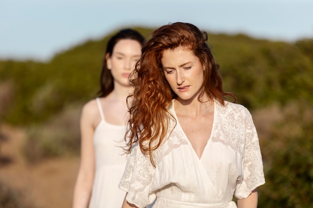 Mujeres de vista frontal con vestidos blancos