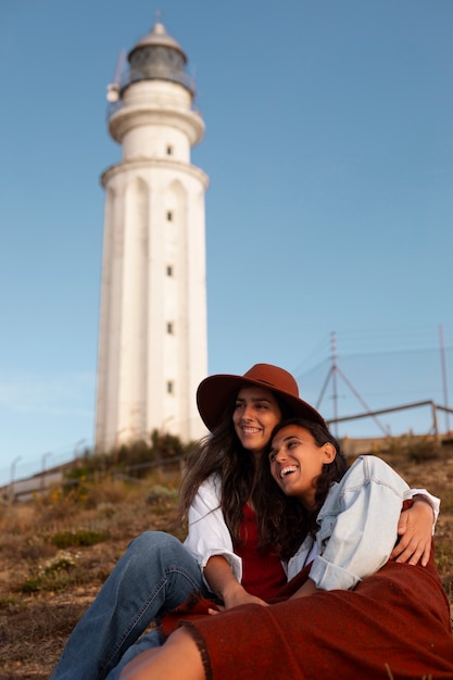 Foto gratuita mujeres de vista lateral posando con un faro