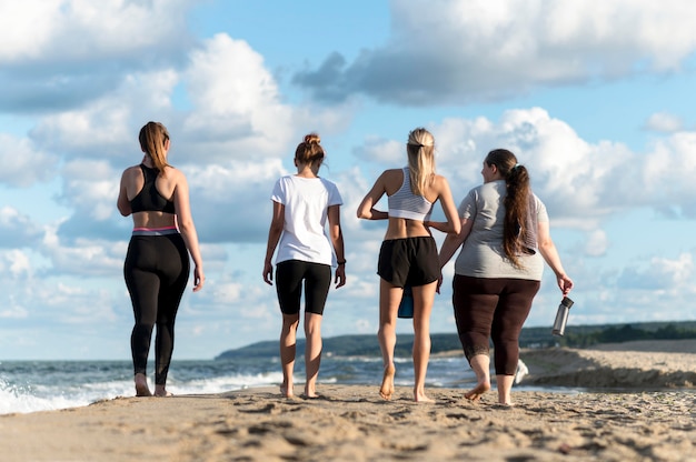 Foto gratuita mujeres de vista trasera caminando en la orilla