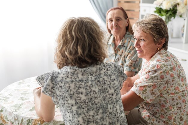 Multi generación mujeres sentadas en la cocina desayunando