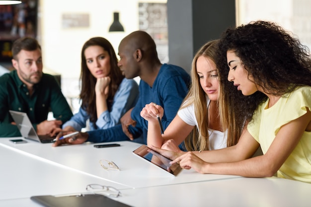 Multiétnico grupo de jóvenes que estudian con ordenador portátil