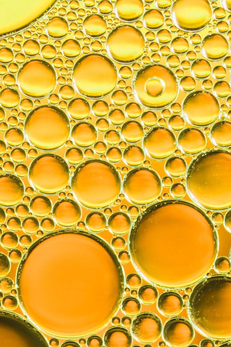 Foto gratuito múltiples burbujas de aire en agua sobre fondo borroso dorado