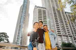 Foto gratuita multirraciales jóvenes amigos de pie contra edificios de la ciudad.