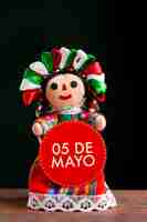 Foto gratuita muñeca mexicana con cartel del 5 de mayo