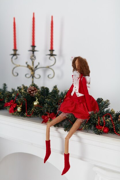 Muñeca sentada en adornos de navidad