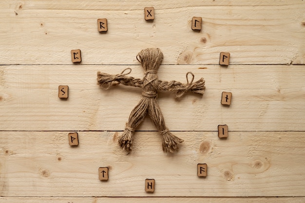 Muñeco vudú de vista superior sobre fondo de madera