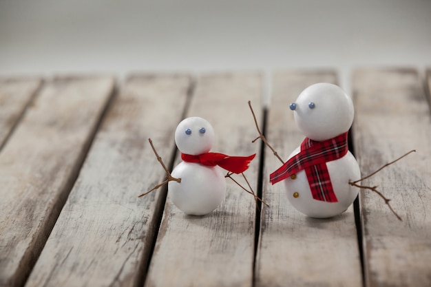 Foto gratuita muñecos de nieve sobre una mesa de madera